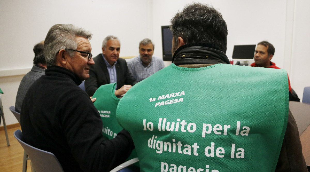 Un pagès amb una armilla on es llegeix “Jo lluito per la dignitat de la pagesia” en una reunió a Tarragona. Sílvia Jardí (ACN)