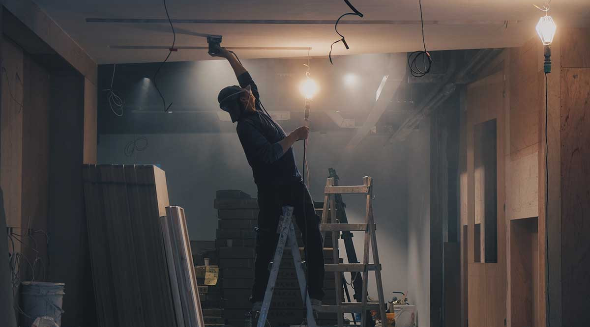 Un treballador construeix el sostre d'un immoble. Henry & Co (Unsplash)