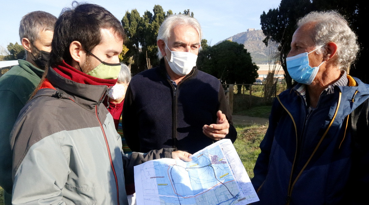 El representants de les entitats naturalistes i el d'Unió de Pagesos, mirant el plànol de les dues alternatives que es proposen per a la variant de Torroella. Xavier Pi (ACN)