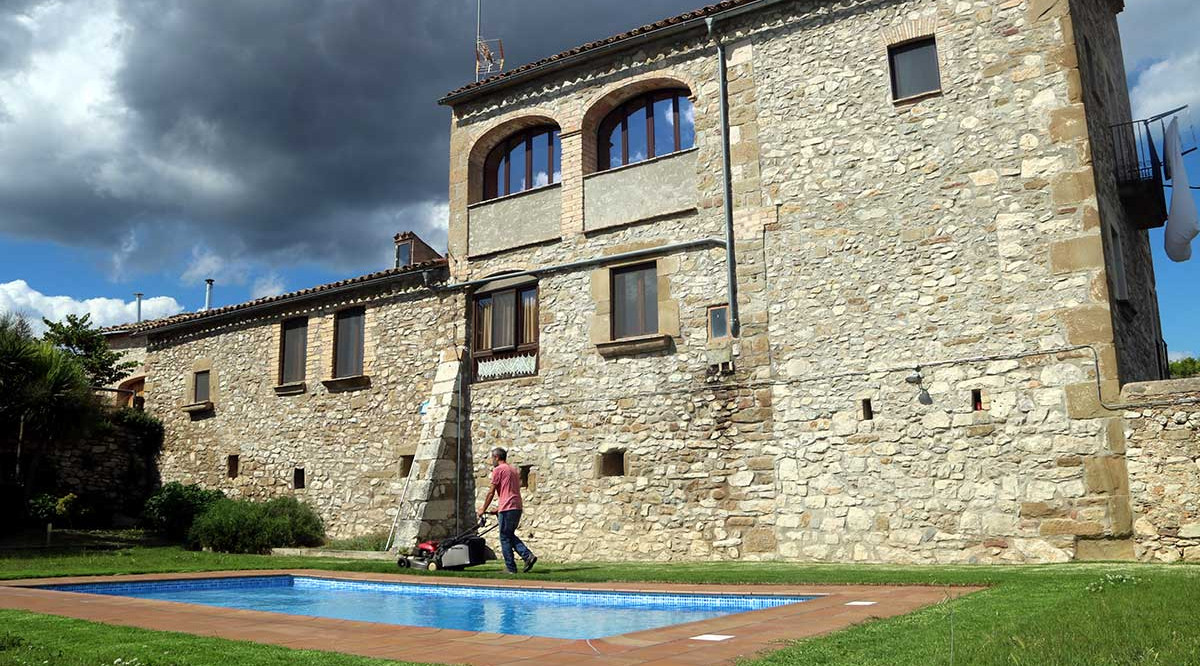 Pla general de la casa de turisme rural Torrecabota de Calders (Bages), amb el seu masover segant la gespa. Estefania Escolà (ACN)