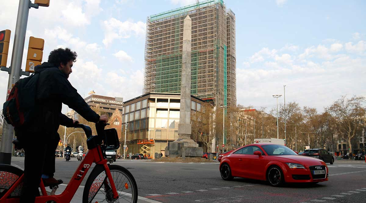 Un home espera creuar en bicicleta el pas de vianants, a tocar de la plaça Cinc d'Oros de Barcelona. Blanca Blay (ACN)